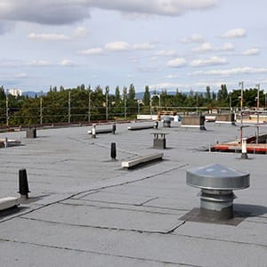 Flat commercial rooftop in Central Illinois with multiple ventilation ducts and exhaust vents.